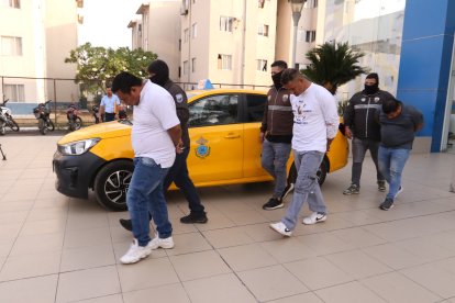 Los detenidos junto al taxi en el que secuestraban y asaltaban a otros ciudadanos.