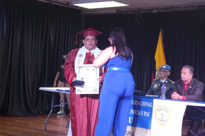 Momento en que el abogado Paúl Moreno, de 35 años, recibe el título de doctorado honoris causa.