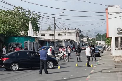 Agentes policiales levantan indicios en el barrio Twintza, sur de Esmeraldas, tras el asesinato a tiros de Vidal Segundo Valencia dentro de su vehículo.