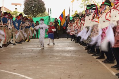 Niños vestidos de payasos y personajes recorren el espacio alrededor de los danzantes mayores en Poaló.
