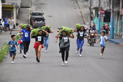 Con racimos de plátano de hasta 20 libras, mujeres y hombres participaron en una carrera.