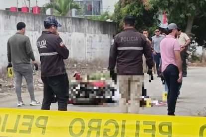 Agentes policiales resguardan la escena donde fueron asesinados Jhon Jairo Lara y Jordy Adrián Corozo, en la isla Vargas Torres, cerca del Centro Forense.