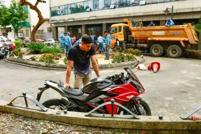 Carlos Burgos mientras revisa los daños que sufrió su motocicleta.