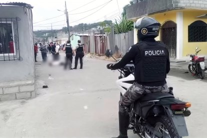 Agentes de la Policía Nacional acordonan el área donde dos hombres fueron asesinados a tiros en el sector Santa Martha #2, Esmeraldas.