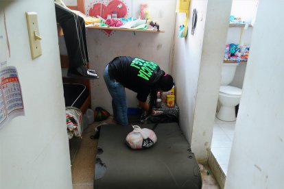 Un agente de Criminalística inspecciona la celda donde fue hallado el cuerpo sin vida de María Eva Paredes Reasco, en el Centro de Rehabilitación Femenino de Esmeraldas.