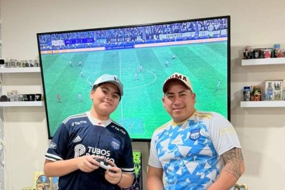 Ahidam (i) y su padre comparten la afición por Emelec y el fútbol hasta en los videojuegos.