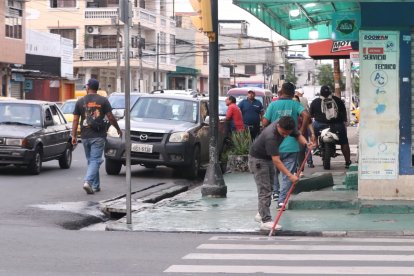 Moradores del sector limpiaban la sangre que quedó en el asfalto tras el crimen.