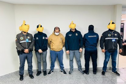 El deportado junto con los policías de migración de Estados Unidos y Ecuador en el aeropuerto de Guayaquil.