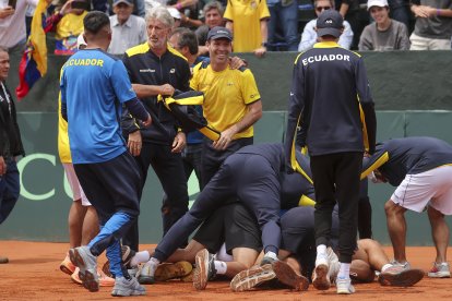 Jugadores e integrantes del cuerpo técnico de Ecuador celebran la clasificación a la segunda ronda tras ganar ante Australia el partido de dobles.