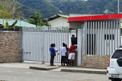 Familiares de las víctimas esperan en las afueras del Centro Forense de Esmeraldas, con documentos en mano, para retirar los cuerpos del triple crimen.