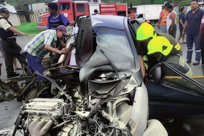 Bomberos y policías trabajan en el rescate tras el violento accidente en Wínchele, donde un automóvil quedó destruido y un adolescente perdió la vida.