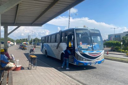 En la parada del puerto de Esmeraldas, un bus de la coop. Las Palmas recoge pasajeros en medio de la dinámica urbana y el comercio callejero.