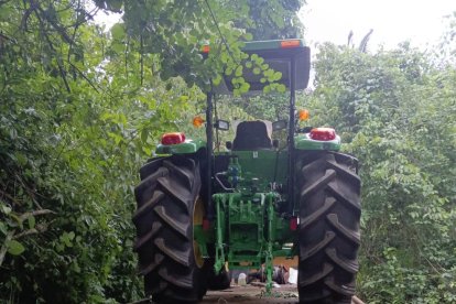 El automotor agrícola recuperado junto a los trabajadores.