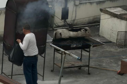 Un hombre quema papeles en la terraza de la Embajada de Cuba en Quito.API