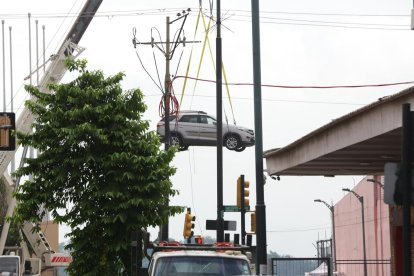 Grúas retiran vehículos atrapados tras el incendio en el edificio Multicomercio de Guayaquil.