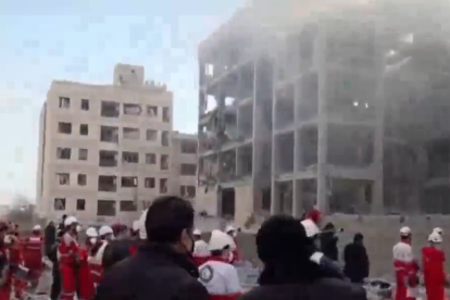 Rescatistas trabajan entre los escombros tras el impacto de un misil en edificios residenciales de Teherán