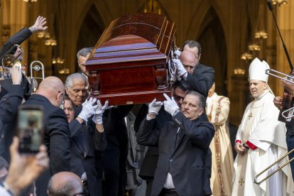 Personas sostienen el féretro del cantante Willie Colón este lunes, al finalizar una misa pública con motivo de su funeral en la Catedral de San Patricio en Nueva York.