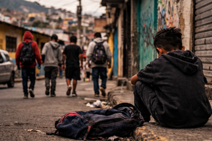 Recreación: niño observa a otros adolescentes en una calle de barrio vulnerable, en una escena que refleja la falta de oportunidades que enfrentan muchos menores.