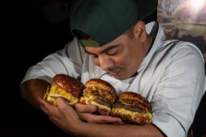 Julio Charco mientras abraza sus creaciones: hamburguesas de autor.