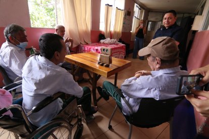 Adultos mayores escuchan y conversan con el asistente de IA durante la actividad organizada por estudiantes e investigadores universitarios.