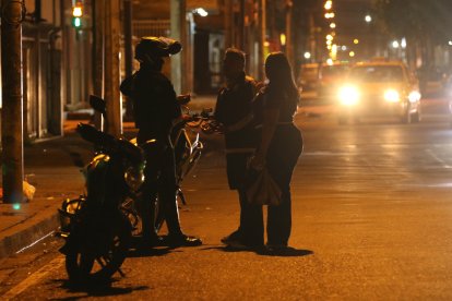 Un integrante de la Policía de Ecuador conversa con ciudadanos tras el toque de queda este domingo, en Guayaquil (Ecuador).