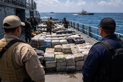Recreación mediante IA de bultos sospechosos siendo inspeccionados en una embarcación en altamar durante un operativo contra el narcotráfico.