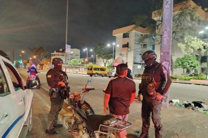 Dean Espinoza fue detenido a las 00:20 del jueves 19 de marzo, mientras atendía una alerta de robo en el vehículo de la empresa de seguridad donde trabaja. Militares de las Fuerzas Armadas lo interceptaron y lo trasladaron a la Fiscalía, donde quedó a órdenes de la autoridad judicial por presunto incumplimiento de decisiones legítimas de autoridad competente.

Su caso fue uno de los 212 registrados en Guayaquil durante los cuatro primeros días del toque de queda. Sin embargo, detrás de estas cifras se esconde un problema: la alta cantidad de detenidos, sumada a la demora en la elaboración de partes policiales, está complicando el trabajo de fiscales y jueces, al punto de que varios aprehendidos terminan en libertad, según denunciaron a EXTRA, bajo anonimato, algunos funcionario judiciales.

La pareja de Espinoza, quien esperaba en los exteriores del Cuartel Modelo, aseguró que él no incumplió la norma de forma intencional. “No lo hizo por desobedecer. Él fue a atender una alerta”, dijo. Pese a mostrar su credencial, fue retenido. Finalmente, en la audiencia de flagrancia, se le dictó la prohibición de salida del país.



Incremento de detenciones

Casos similares se han repitido. La noche del primer día del toque de queda, un grupo de jóvenes peloteros fue retenido luego de que una llanta pinchada retrasara su movilización. Fueron llevados a la Unidad de Flagrancia del Cuartel Modelo, donde permanecieron varias horas antes de quedar en libertad.

Un fiscal explicó que se trataba de 10 deportistas retenidos en Sauces. “Se dispuso a la Policía que elabore los partes y verifique antecedentes para agilizar el proceso”, indicó.

Otro grupo, conformado por viajeros, también fue aprehendido por exceder el horario. Tras justificar su presencia en la vía pública, recuperaron su libertad.



La flagrancia al límite

Un representante del Ministerio Público advirtió que, con el toque de queda, la carga de audiencias se disparó. En unidades como Valdivia y La Florida, varios casos llegan al filo de las 24 horas que establece la flagrancia.

“Los detenidos están siendo presentados casi al límite. Si no se alcanzan a procesar a tiempo, deben ser liberados”, explicó.

Otro funcionario detalló el problema logístico: “La Policía trasladó entre 30 y 50 personas por día. Cada detenido requiere un parte individual. Aunque la audiencia sea rápida, registrar cada caso puede tomar hasta 15 minutos. En ocasiones, deben ser liberados porque se vence el tiempo”.

En Guayaquil operan dos unidades de flagrancia: Cuartel Modelo (norte) y Valdivia (sur y suburbio), mientras que La Florida (noroeste) atiende principalmente a menores de edad infractores.



Casos y cuestionamientos

La mayoría de detenciones corresponde a personas que circulaban en la vía pública sin justificación o bajo efectos del alcohol. También hay casos de trabajadores informales.

“En un día recibimos tres cuidadores de carros detenidos. Son personas que trabajan honradamente. Se debe analizar mejor estas situaciones”, señaló un funcionario, quien ordenó su liberación.

El artículo 282 del Código Orgánico Integral Penal (COIP) sanciona el incumplimiento de decisiones de autoridad con penas de uno a tres años de prisión.

Este Diario solicitó al Consejo de la Judicatura información sobre cuántos detenidos han sido liberados y cuántos permanecen aprehendidos, pero hasta el cierre no hubo respuesta.

Según el Gobierno, durante la primera semana del toque de queda se registraron 897 detenidos. Entre ellos, también se reportó la captura de un objetivo criminal priorizado, conocido como ‘Wiwi’ o ‘Teniente’, presunto integrante de Los Choneros.