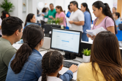 Traslados de fiscal a fiscal en 2026 en Costa: recreación mediante IA de padres que realizan el proceso de traslado estudiantil en línea para el régimen Costa–Galápagos.