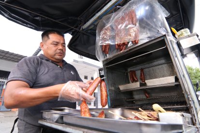 Orlando usa guantes de plástico para servir sus chorizos.