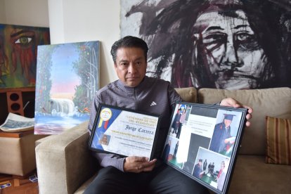 Jonnathan Carrera con varias fotos y placas de los reconocimientos que recibió su padre por el aporte para dar identidad, normativa y masificación del ecuavóley