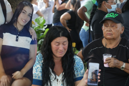 Katty Loor llora al ver las fotos de su hija Ariana almacenadas en su celular. Recibe el consuelo de sus allegados.