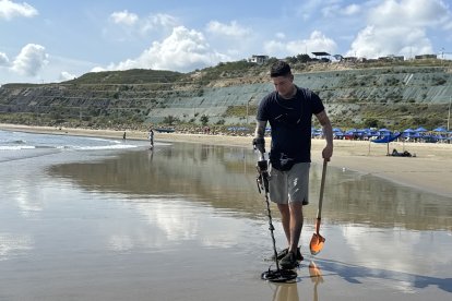 Bryan Zambrano mientras recorre la playa de San Mateo, en Manta, en busca de objetos de valor que quedan enterrados tras la marea.