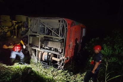 La unidad de transporte interprovincial quedó volcada a un costado de la vía E20, mientras equipos de rescate trabajaban en la noche para liberar a los heridos y asegurar la zona.