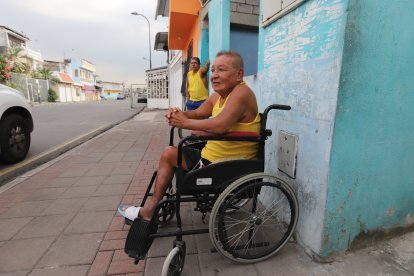La vereda afuera de su casa se ha convertido en su refugio para escapar del encierro y la tristeza.