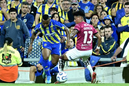 Jáminton Campaz (i) de Rosario disputa un balón con Daykol Romero de Independiente del Valle .