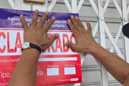 Imagen referencial. Funcionario colocando sello de clausura en un local comercial.