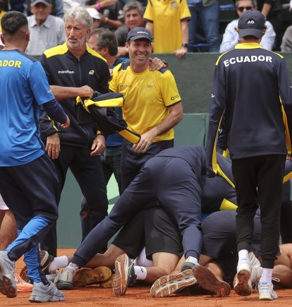 Jugadores e integrantes del cuerpo técnico de Ecuador celebran la clasificación a la segunda ronda tras ganar ante Australia el partido de dobles.