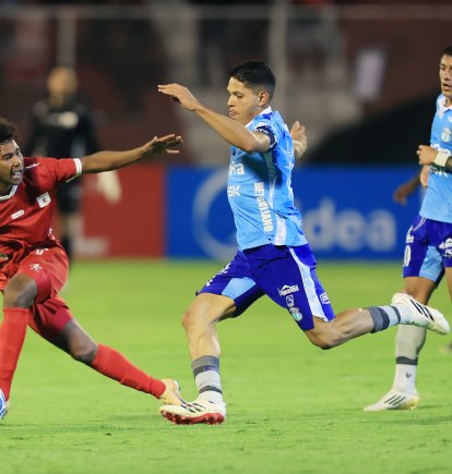 José Marrufo (c) de Macará disputa un balón con Jorge Valencia (i) de América .