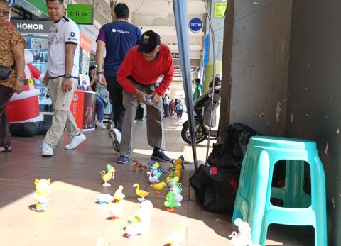 Transeúntes y trabajadores de la zona observan el espectáculo de los animalitos de juguete que pondrá en promoción Ramón Recalde.