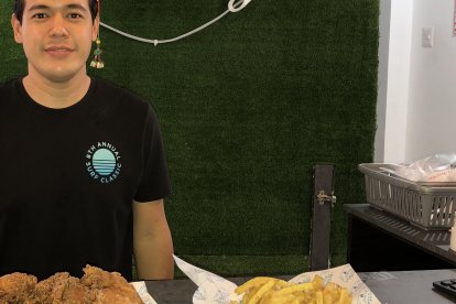 Andrés Angueta y las especialidades de su local: pollo, wantanes y papas.