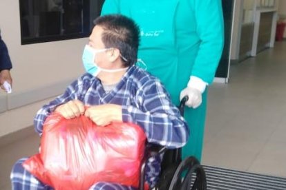 Momento en el que es sacado del hospital en silla de ruedas.