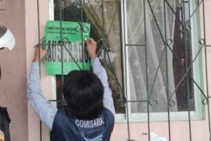 Una funcionaria de la Gobernación del Guayas coloca el sello de clausura a uno de los establecimientos.
