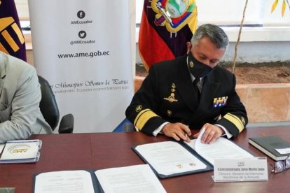 Los titulares de la AME y la Dirección General de Intereses Marítimos, al firmar el documento.