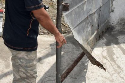 Wilfrido Véliz muestra los daños que supuestamente causó en la puerta de ingreso a su vivienda.