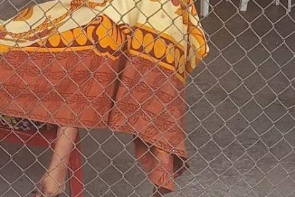 El cadáver de la mujer quedó sobre la silla roja donde estaba sentada. Fue cubierto con una sábana.