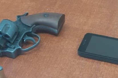 Esta arma de fuego y dos celulares se halló en poder del extranjero.