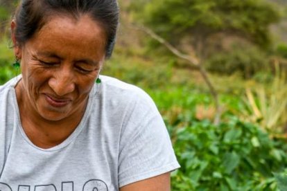 Yolanda Suárez muestra satisfecha los pimientos que está cosechando.