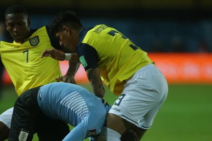 Agustín Álvarez de Uruguay disputa el balón con Pervis Estupiñán (i) y Piero Hincapie (d) de Ecuador.