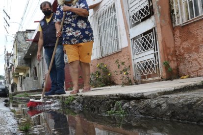 Desde las 05:00, Violeta ‘baldeó’ la calle para desfogar el agua lluvia, en La Chala.