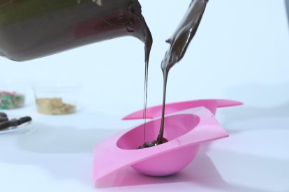 Fase 1. Derrite el chocolate en baño María o un microondas por 20 segundos. Repite el proceso 3 o 4 veces hasta que el chocolate quede fluido y rellena los moldes con dos cucharadas de chocolate. Cubre la mitad de cada esfera y llévalas a refrigeración por 10 minutos.